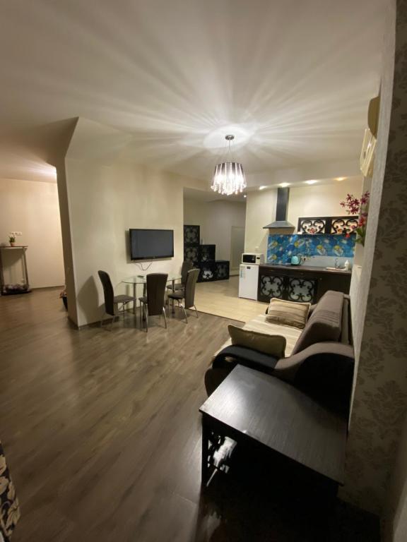 a living room with a couch and a dining room at Most City Apartments Magnolia in Dnipro