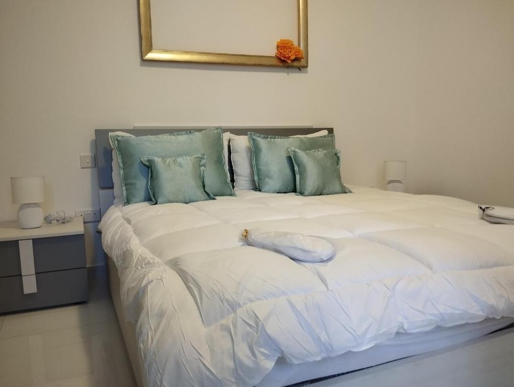 a large white bed with a stuffed animal on it at Pearl Apartments in Sliema
