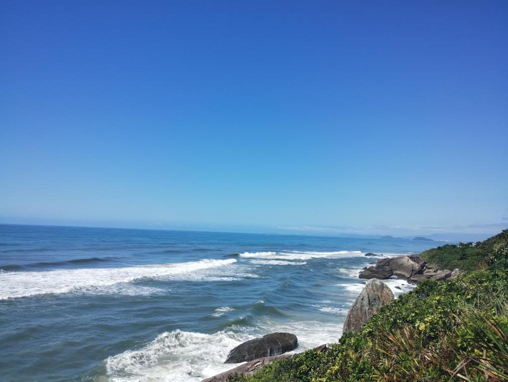 uma vista para o oceano com rochas na costa em Cantinho do descanso em Bertioga