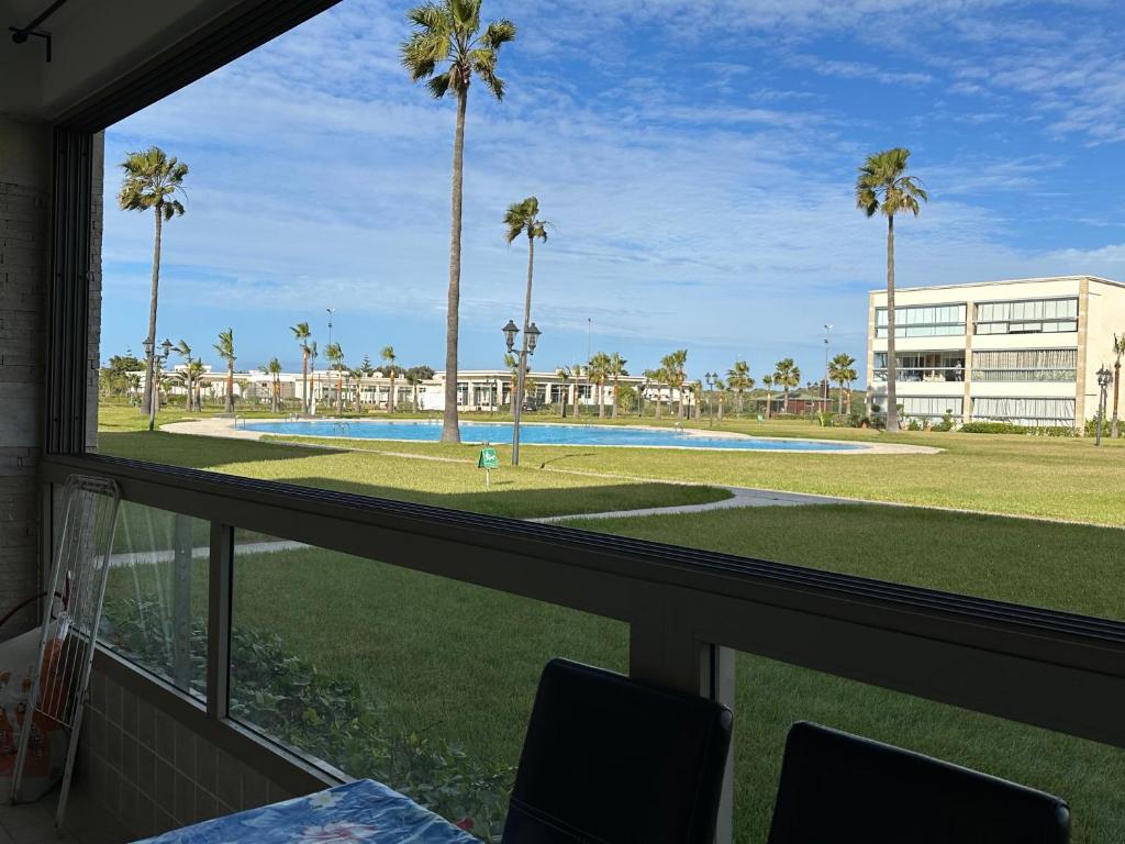 a view of a pool from a window at Très bel appartement à OLA BLANCA in Sidi Rahal