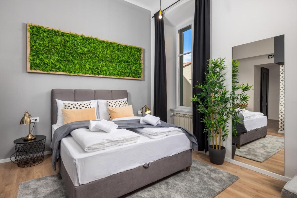 um quarto com uma cama e uma parede verde em Molo Longo - Downtown Apartments em Rijeka