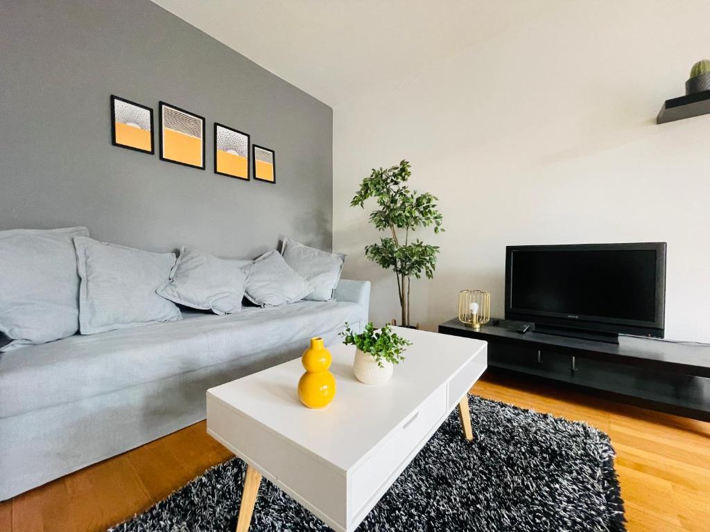 a living room with a gray couch and a white coffee table at Bp-EST CP in Budapest