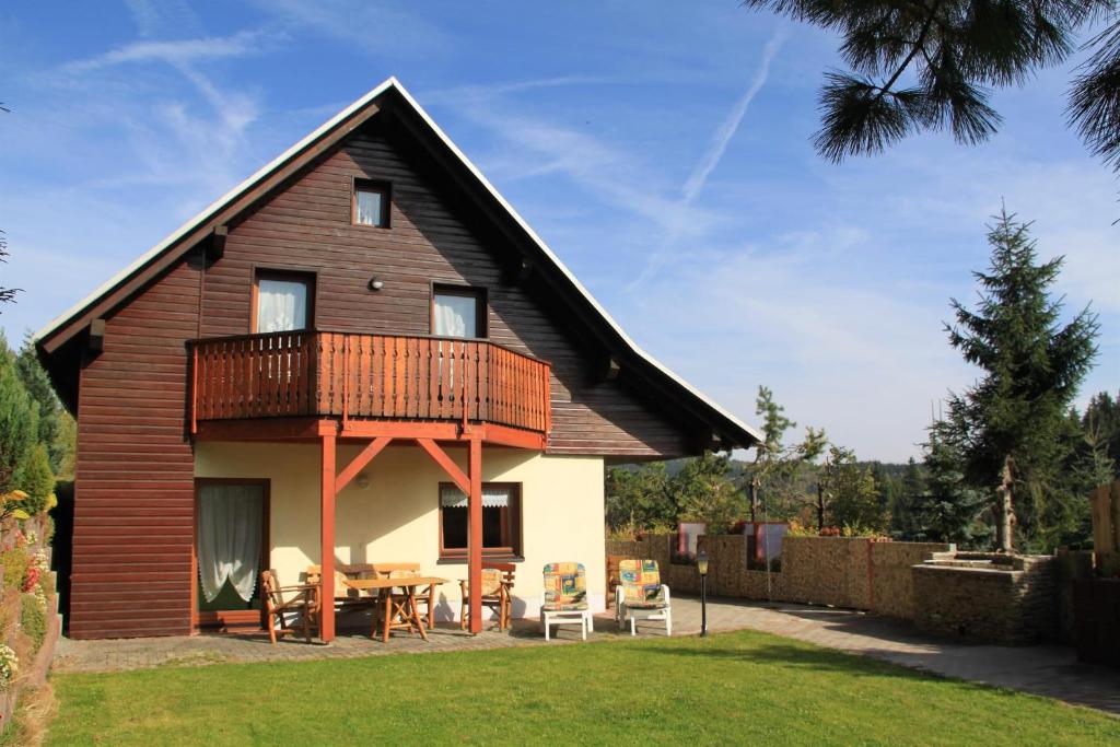 ein Holzhaus mit einer Terrasse und einem Tisch in der Unterkunft Ferienhaus Bauer in Kurort Oberwiesenthal