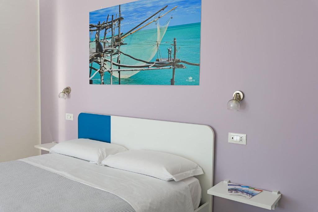 una camera da letto con un letto e un dipinto sul muro di Villa Caravaggio Comfort e Relax a Rocca San Giovanni
