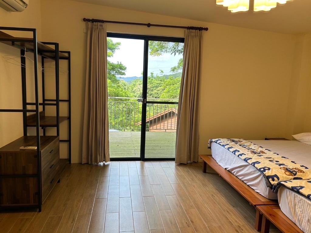 a bedroom with a bed and a large window at Xianyan Villa B&B in Sanyi