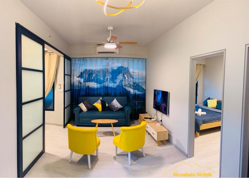 a living room with yellow chairs and a couch at JQ Citypads by Golden Stay in Kota Kinabalu