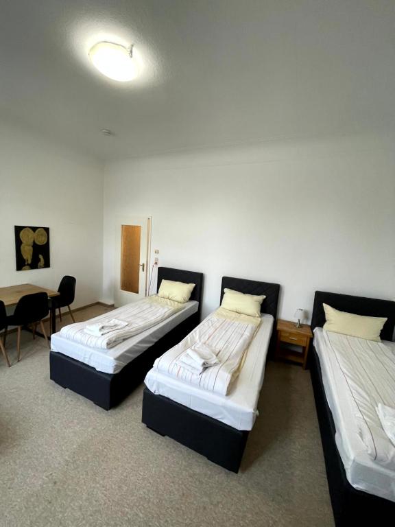 - 2 lits dans une chambre avec une table et des chaises dans l'établissement Monteurwohnung am Holstein-Center, à Itzehoe