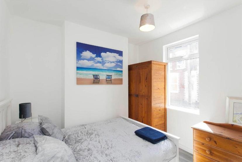 a bedroom with a bed and a picture of the beach at House @ Queens University in Belfast