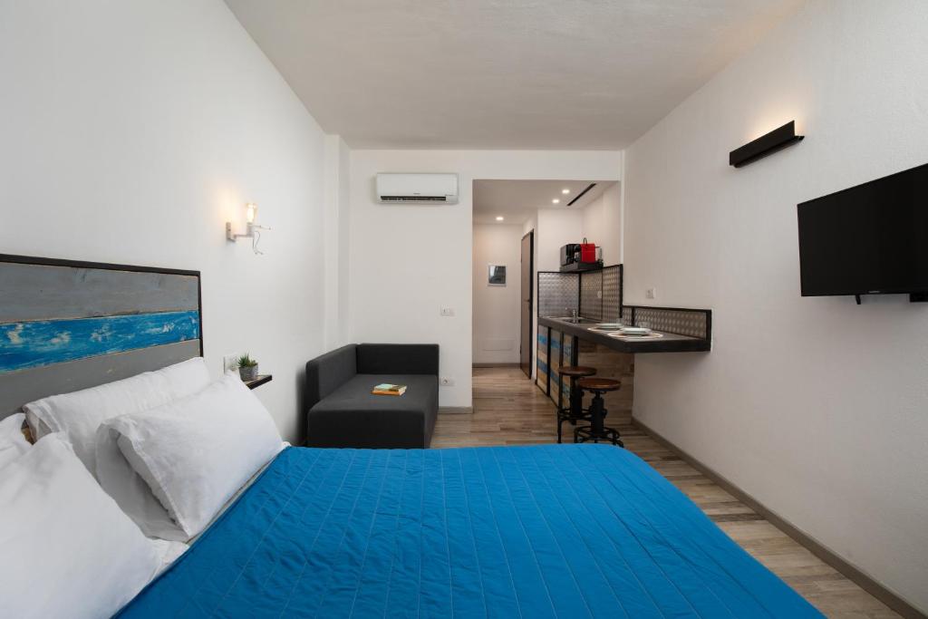 a bedroom with a blue bed and a desk at OlbiaLoft in Olbia
