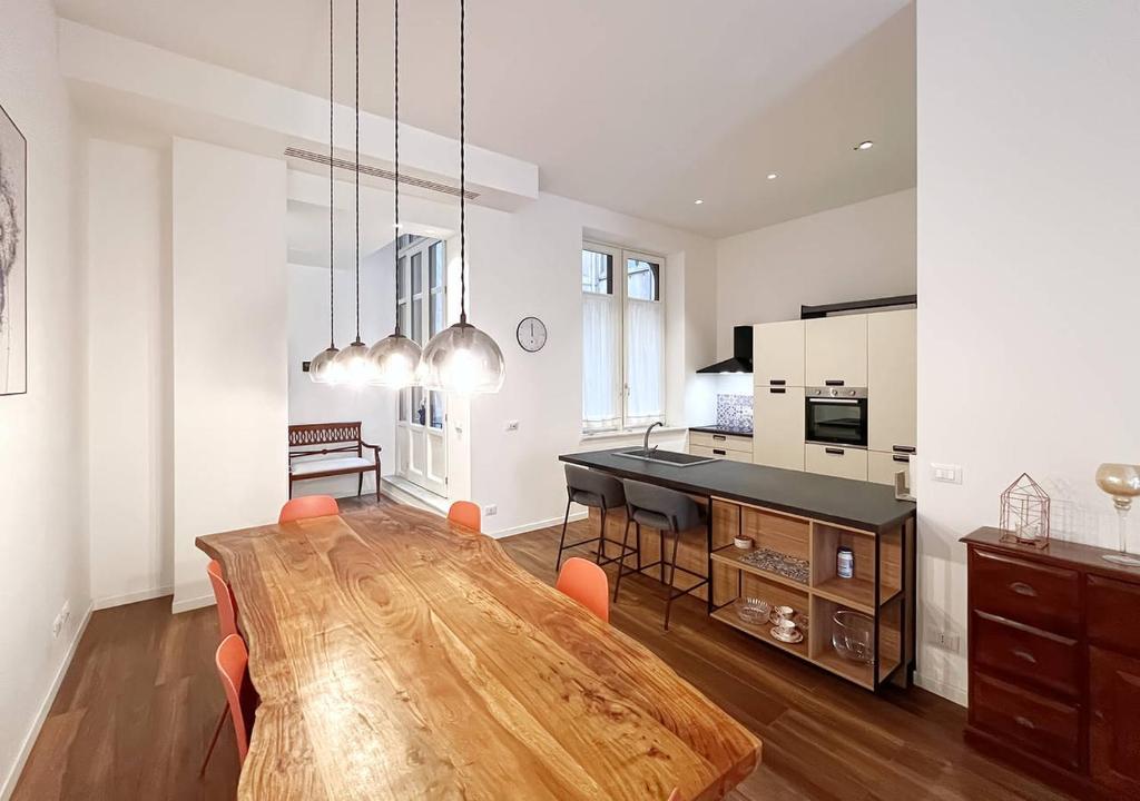 a kitchen and dining room with a wooden table at Solemar Sicilia - Palazzo Pirrotta in Palermo