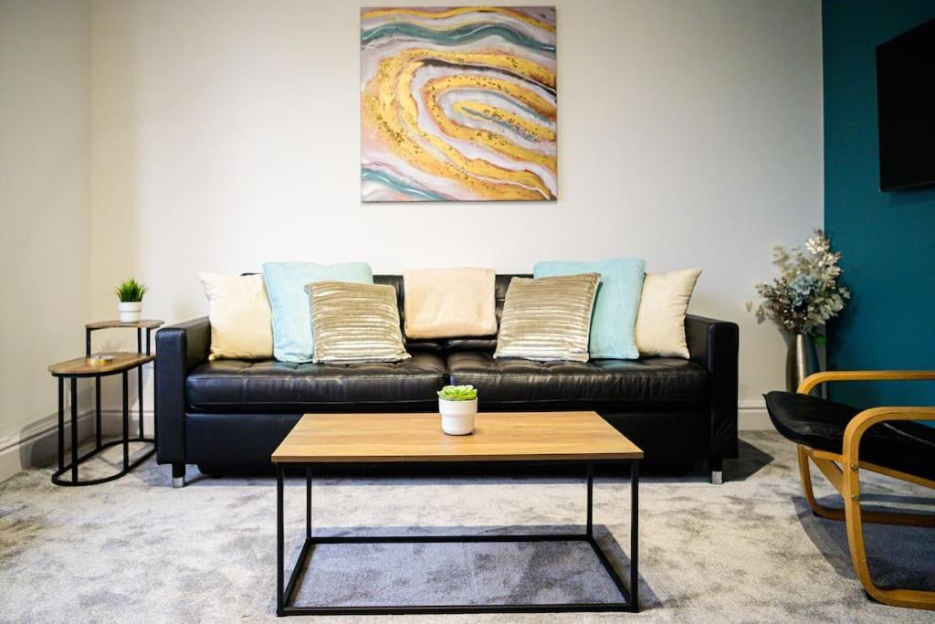 ein Wohnzimmer mit einem Sofa und einem Tisch in der Unterkunft Aqua Springs, luxury 2 bed, 2 bath apartment, near Didsbury in Manchester