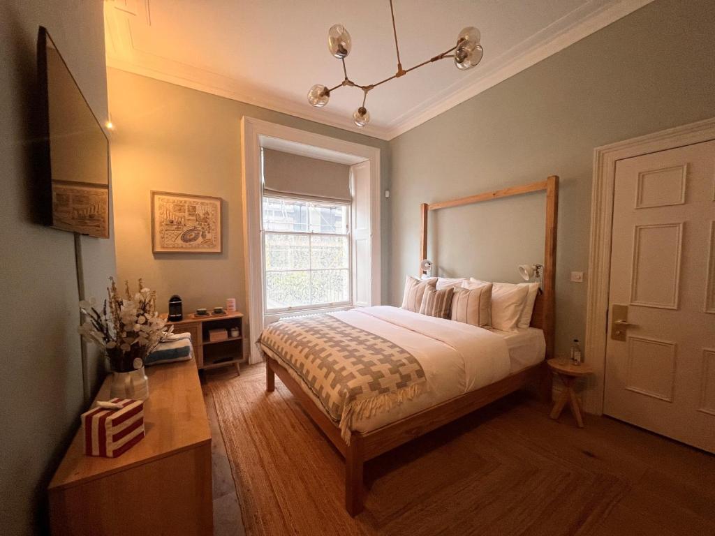 a bedroom with a bed and a window at Lido Townhouse in Bristol