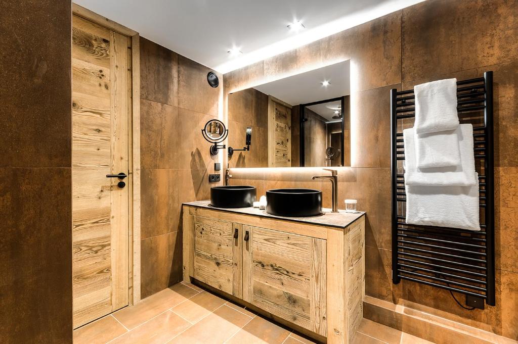 a bathroom with two sinks and a mirror at Hôtel La Sivolière in Courchevel