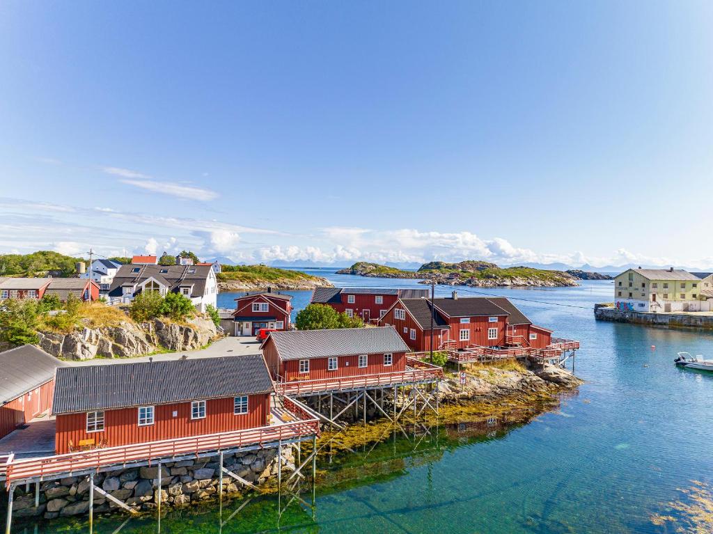 una ciudad en el agua con casas rojas en Henningsvær Rorbuer, en Henningsvaer