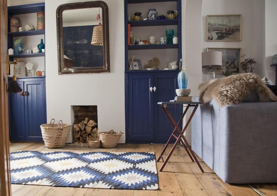 a living room with blue cabinets and a rug at Whitstable Cottage - Perfect Location in Whitstable