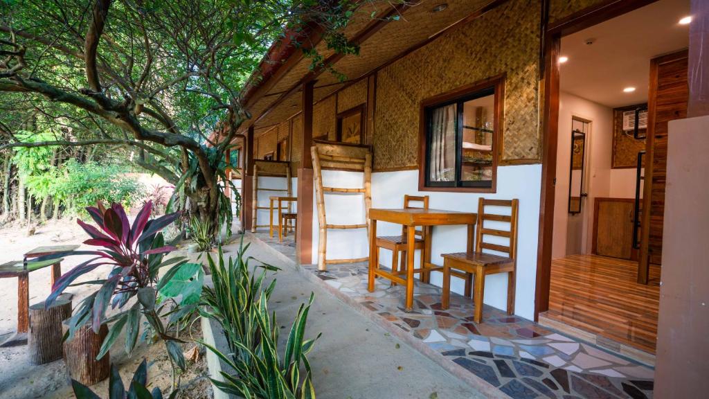 une maison avec une table et des chaises sur la terrasse couverte dans l'établissement Masayana, à El Nido