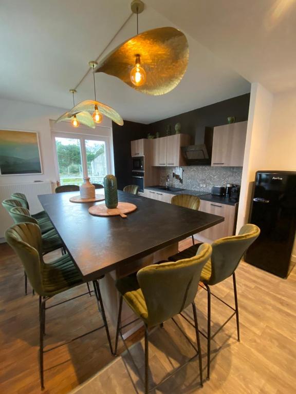 - une cuisine avec une table à manger et des chaises dans l'établissement Villa des Pins, à Jullouville