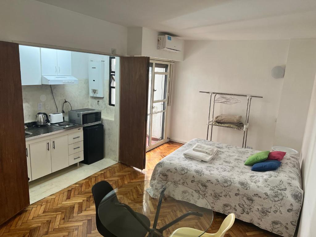 Habitación pequeña con cama y cocina en Studio French - Recoleta en Buenos Aires