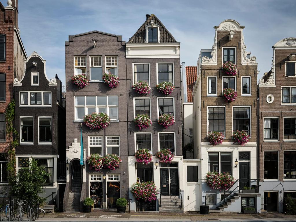 un grupo de edificios con macetas en sus ventanas en Max Brown Hotel Canal District, part of Sircle Collection, en Ámsterdam