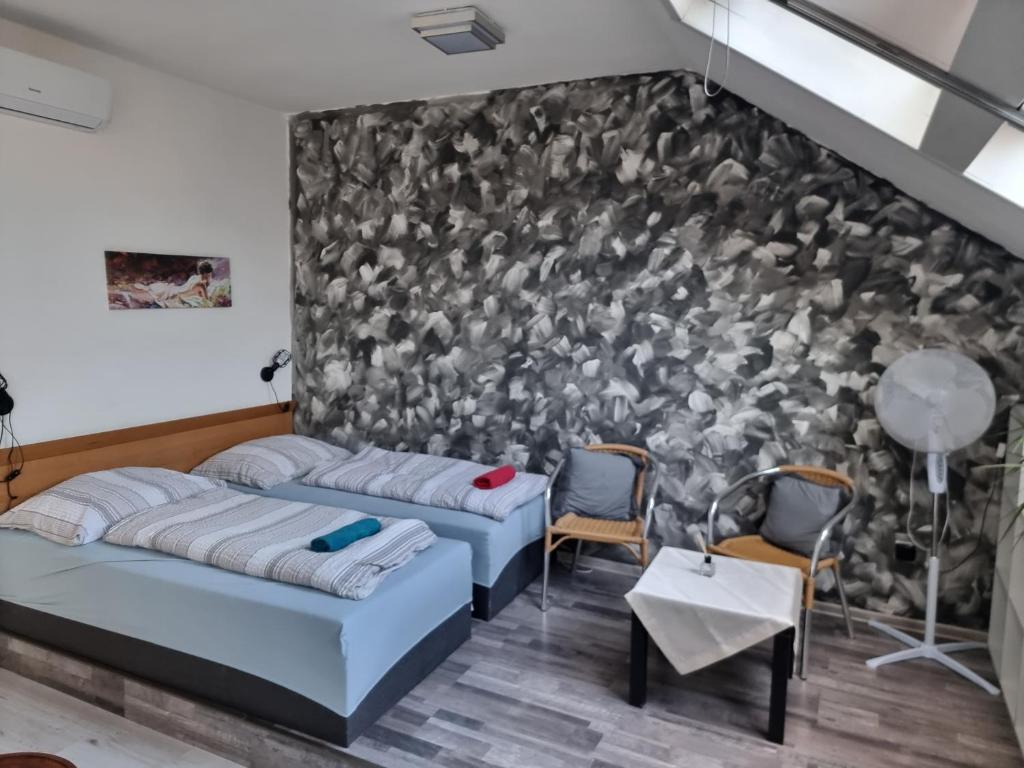 two beds in a room with a wall of birds at Penzion a Víno in Břeclav