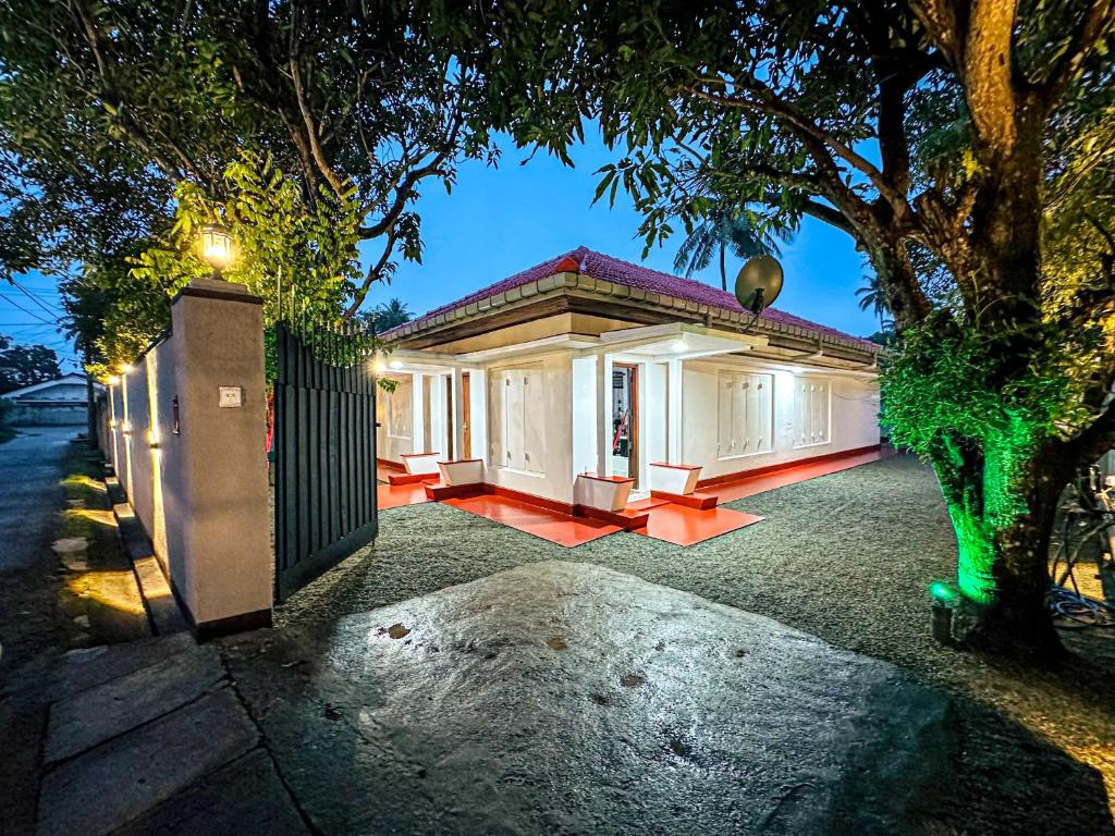 a house with a tree in front of it at Villa Beach Heaven in Hikkaduwa
