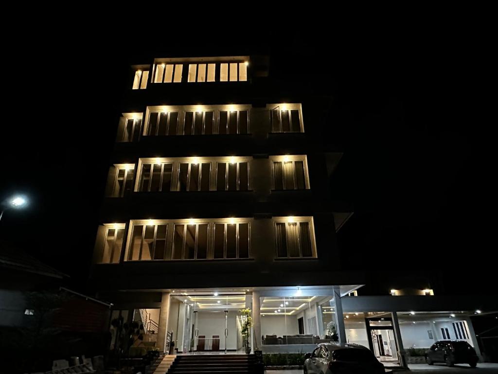 a tall building with lights on it at night at Grands Orchid Hotel in Lahat