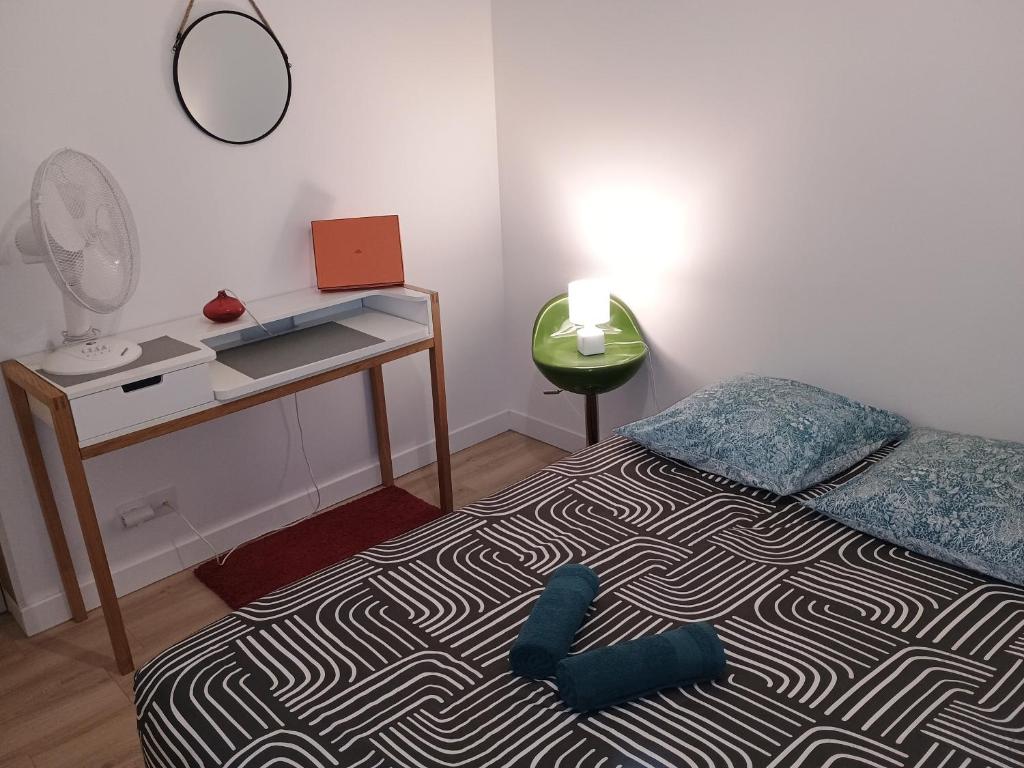 a bedroom with a bed with a desk and a mirror at appartement 2 pieces ,paris proche in Saint-Ouen