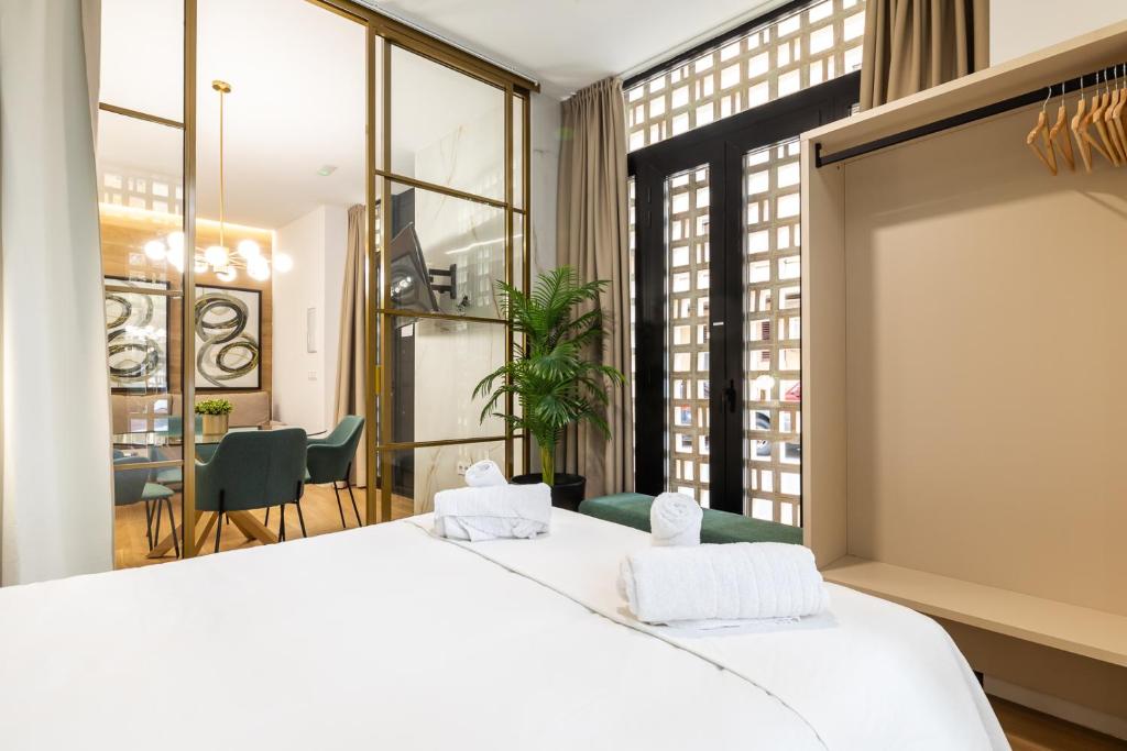 ein Schlafzimmer mit einem weißen Bett und einem großen Fenster in der Unterkunft Anelsa Torres de Serranos 3 in Valencia
