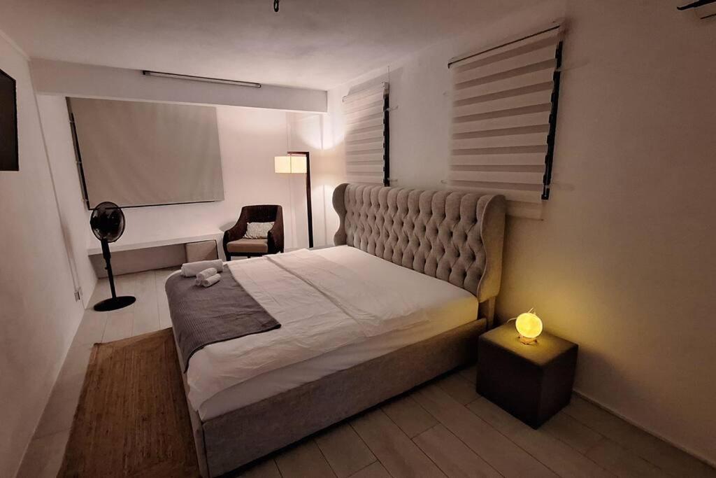 a bedroom with a large bed and a chair at White Bliss in Terre Rouge