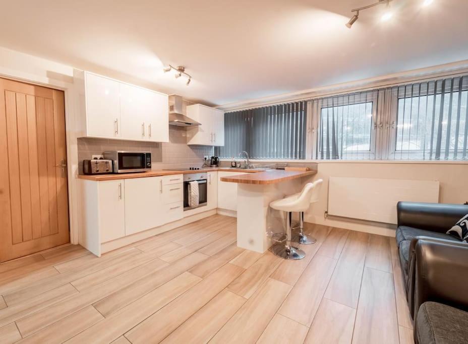 uma cozinha com armários brancos e uma mesa num quarto em Contractors - International - City Centre em Birmingham