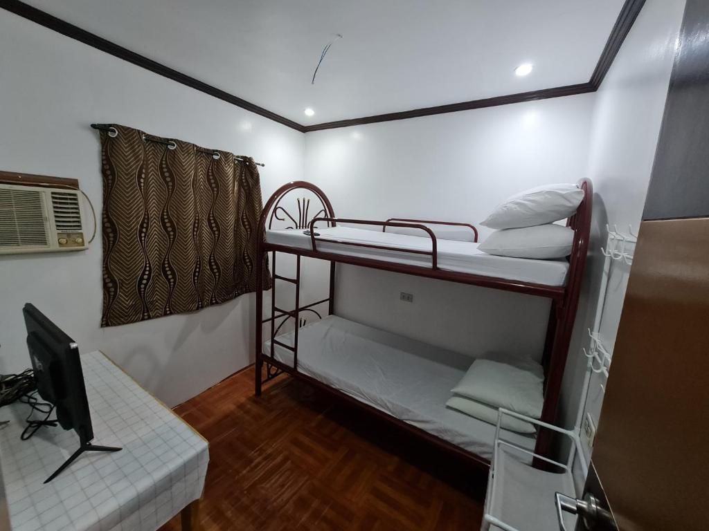 Habitación con 2 literas y TV. en Isla Fatima Private Resort, en Guagua