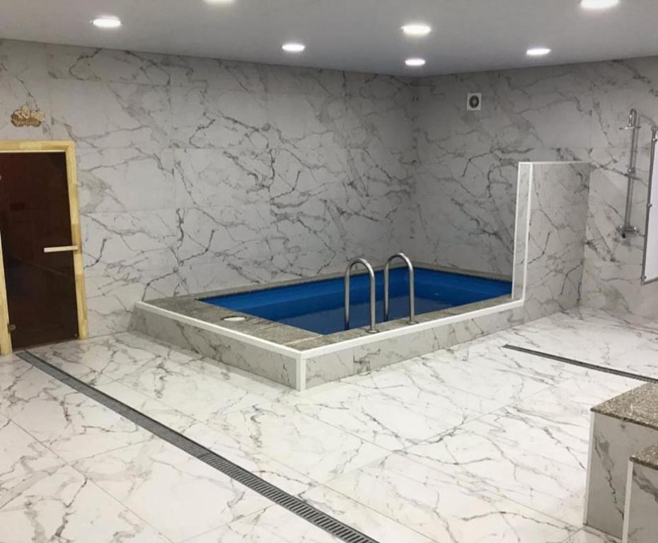 a bathroom with a sink in a marble wall at Ровный in Almaty