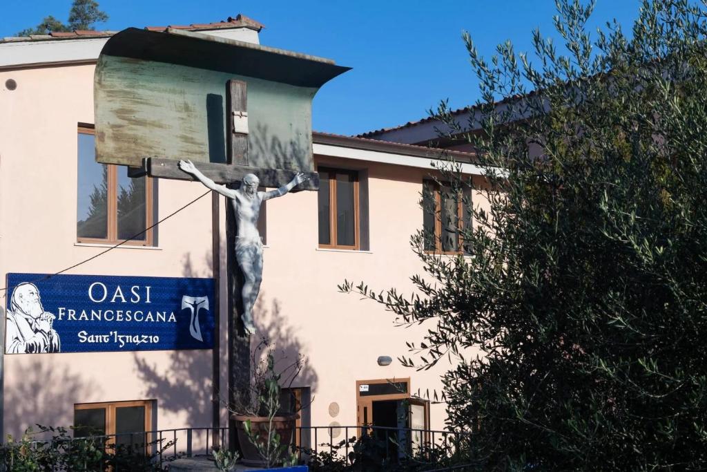 un bâtiment avec une statue devant lui dans l'établissement OASI FRANCESCANA SANT'IGNAZIO DA LACONI, à Làconi