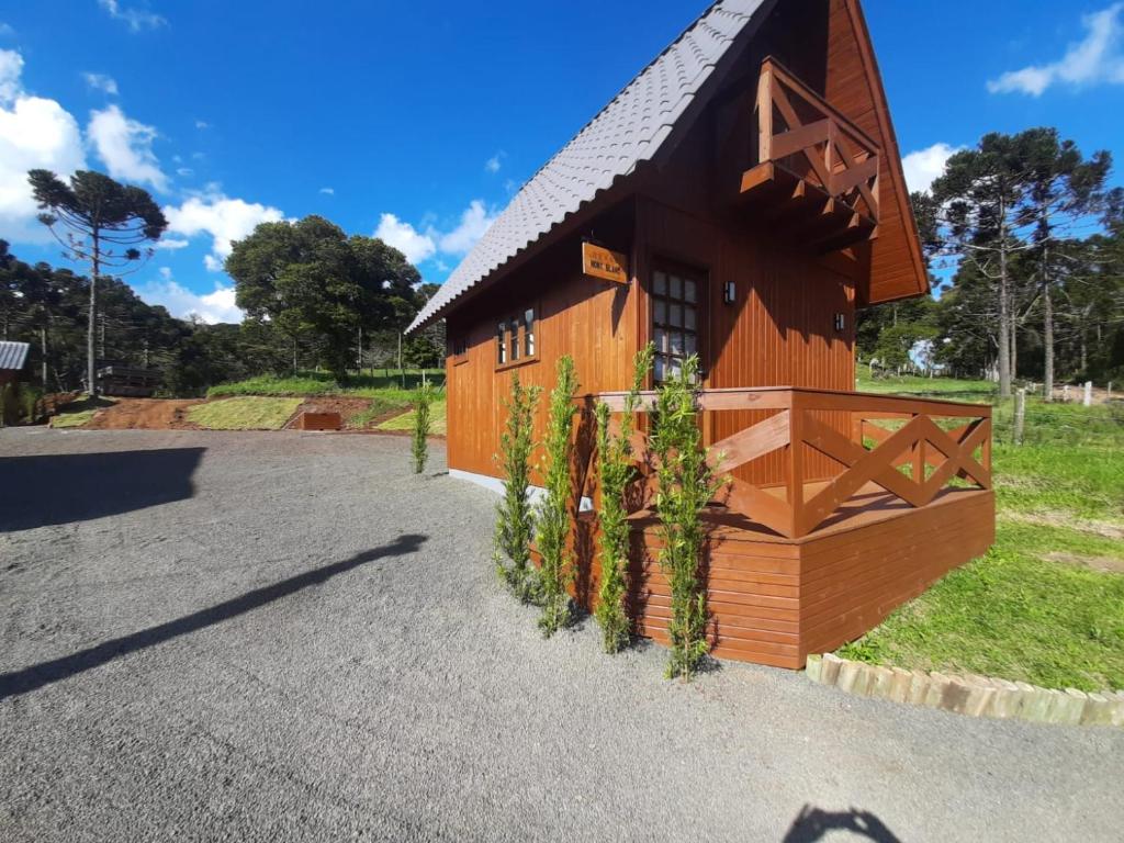 a small wooden house with a gambrel roof at Chalés Altos Da Montanha - Mont Blanc in Bom Jardim da Serra