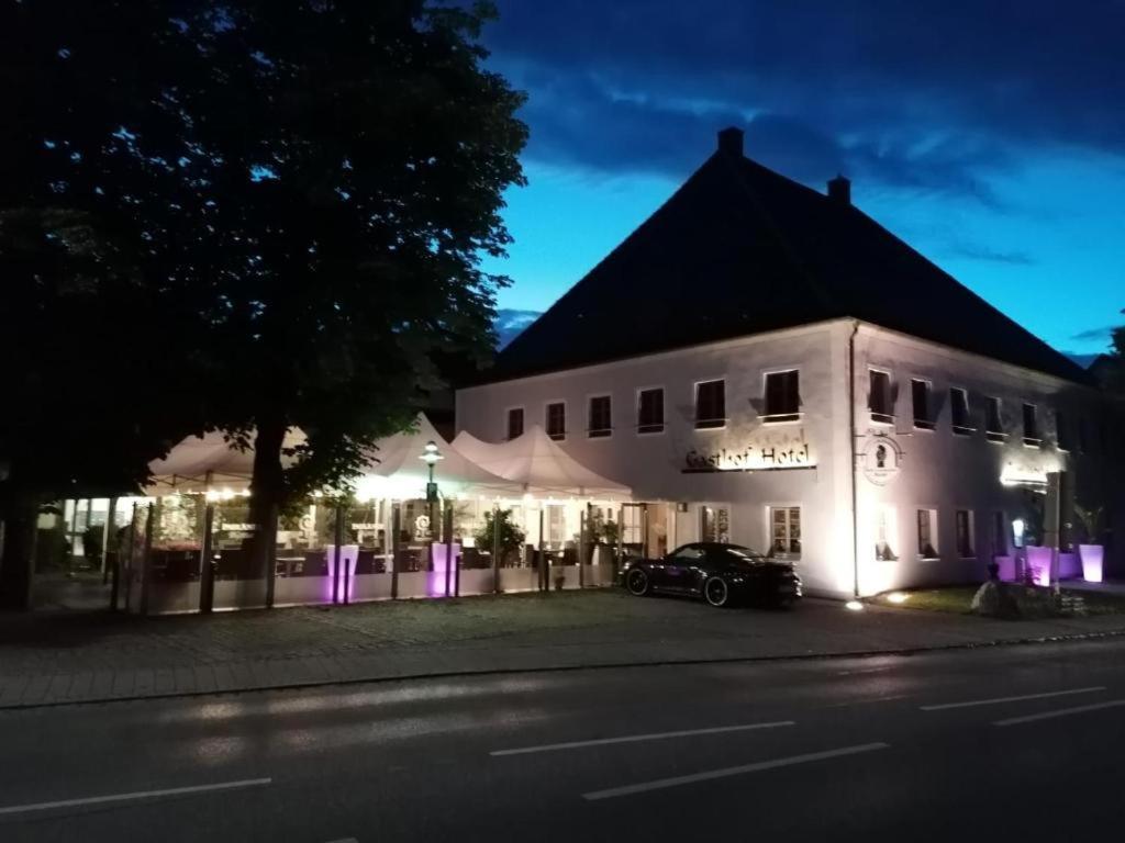 a white building with a car parked in front of it at Hotel Restaurant Zum Wendelwirt in Germaringen