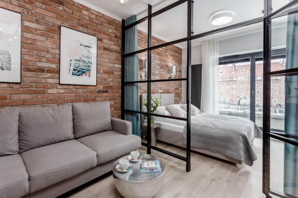 a living room with a couch and a bed at DEO PLAZA - Apartments at the Old Town in Gdańsk