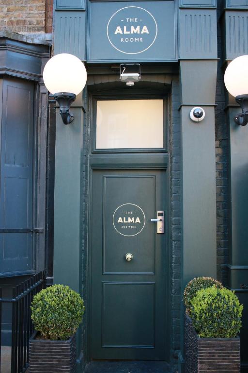 una puerta verde en un edificio con un cartel encima en The Alma Rooms, en Londres