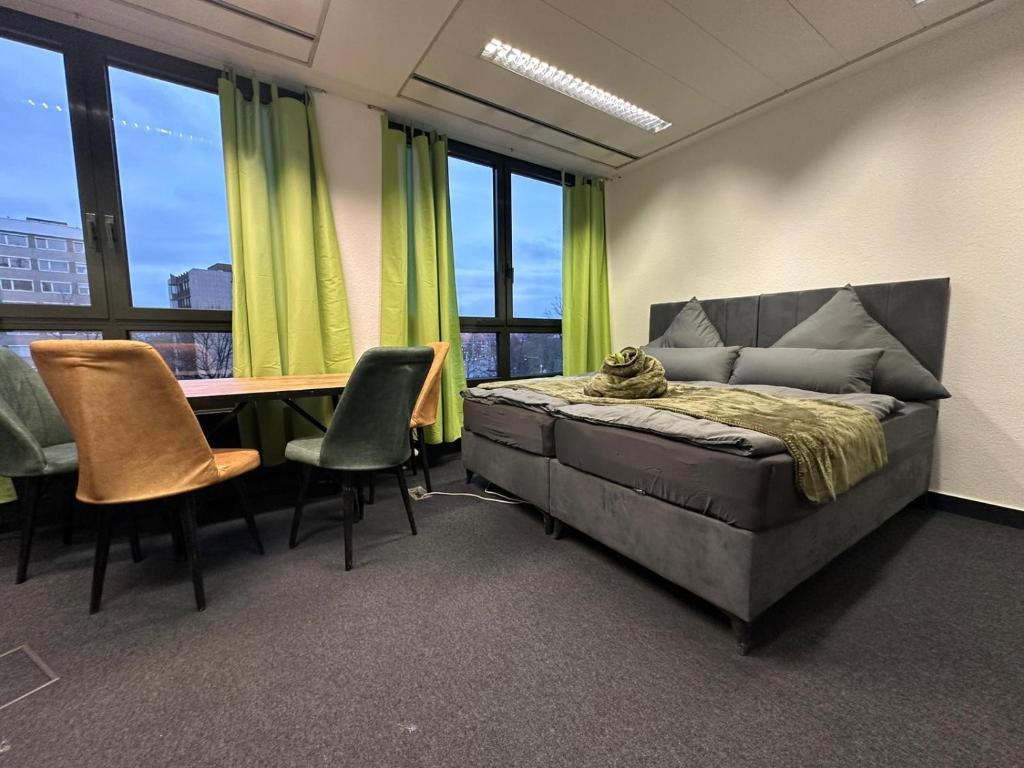 um quarto com uma cama, uma mesa e cadeiras em Pension Bavaria Immobilien em Nurembergue