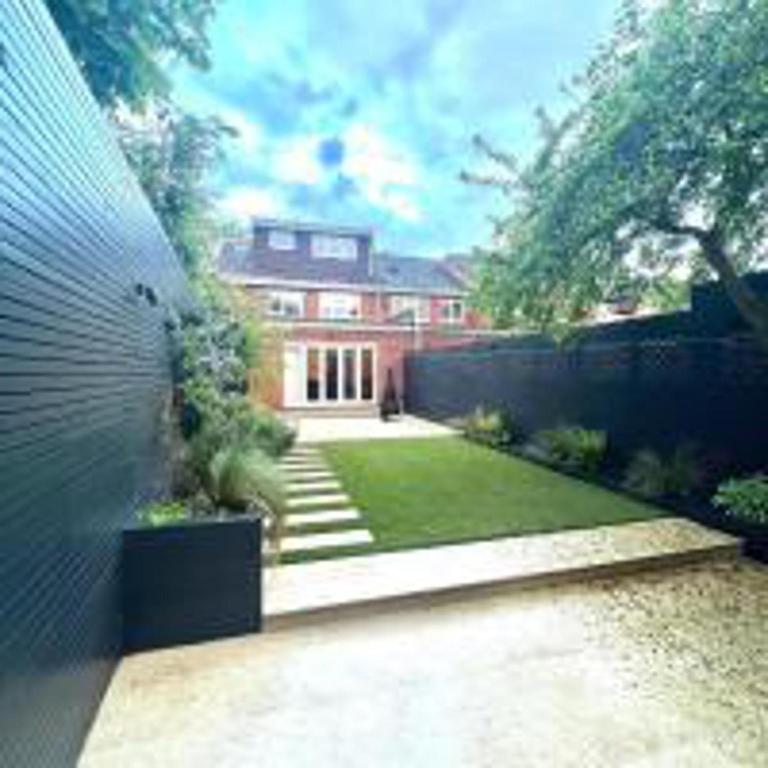 uma casa com um quintal com uma cerca em Inviting 4-Bed House in Finchley London em Hendon