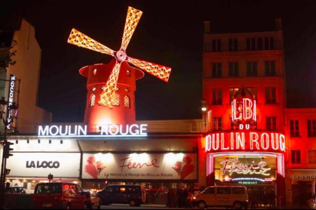 un bâtiment avec un moulin à vent en haut dans l'établissement Paris Sacré Coeur Montmartre et Tour Eiffel, 8 people,, à Paris
