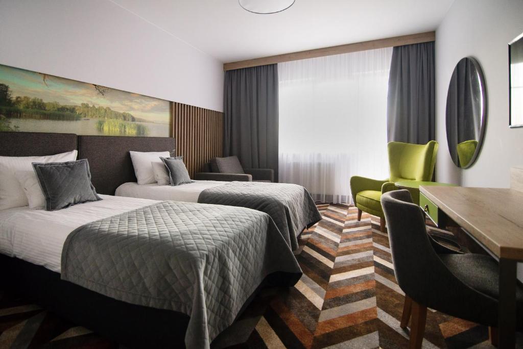 a hotel room with two beds and a desk at Hotel Anders in Stare Jabłonki