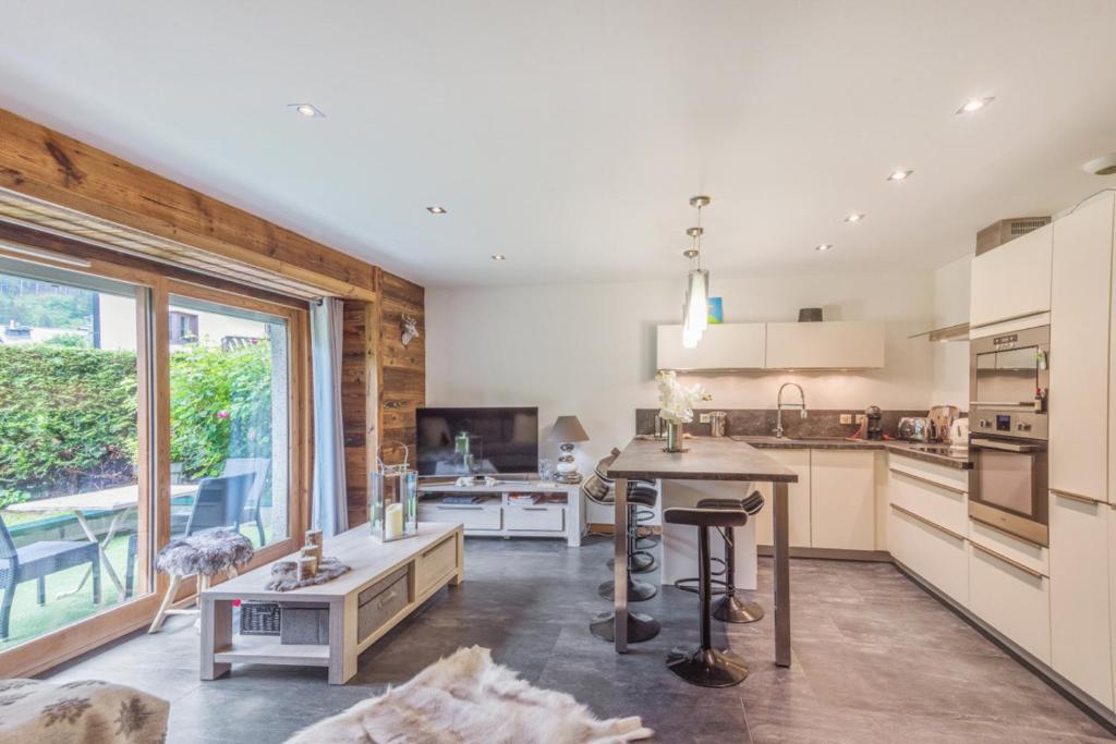 une cuisine avec une table et une grande fenêtre dans l'établissement Villa Princesse - Centre-ville - Renove, à Chamonix-Mont-Blanc