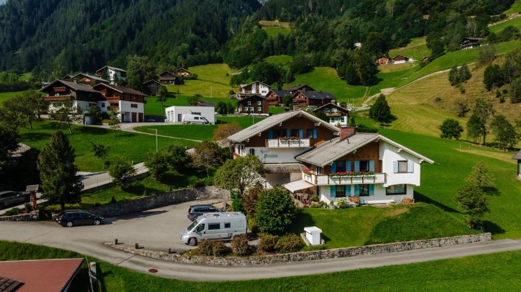 uma aldeia nas montanhas com uma carrinha estacionada na entrada em Haus Platina em Sankt Gallenkirch