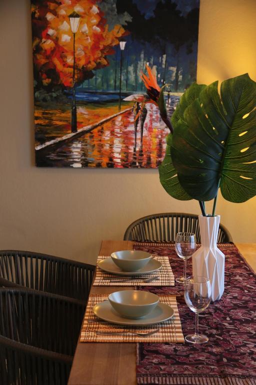 uma mesa com dois pratos e um vaso sobre ela em Tropical Old Town Marbella em Marbella