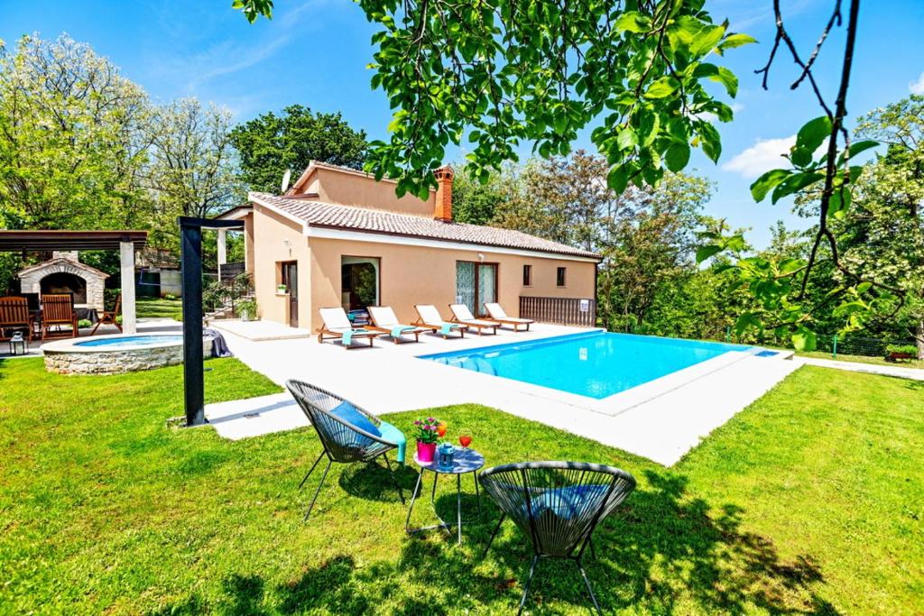 a backyard with a pool and a house at Villa Ferlini in Central Istria with private 10000 m2 Garden in Svetvinčenat