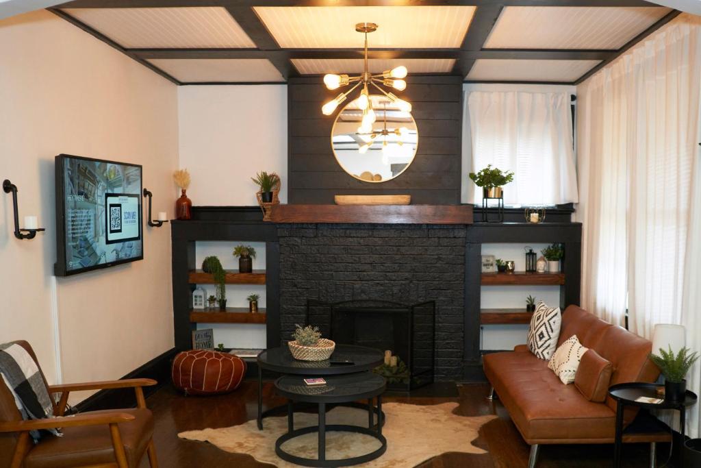 a living room with a brick fireplace and a chandelier at Cozy Atl Getaway - 5 Min From Airport & Downtown in Atlanta