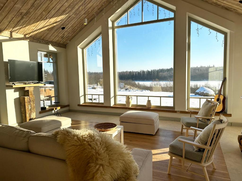 a living room with a couch and some windows at Dabintos slėnis in Sumiliszki