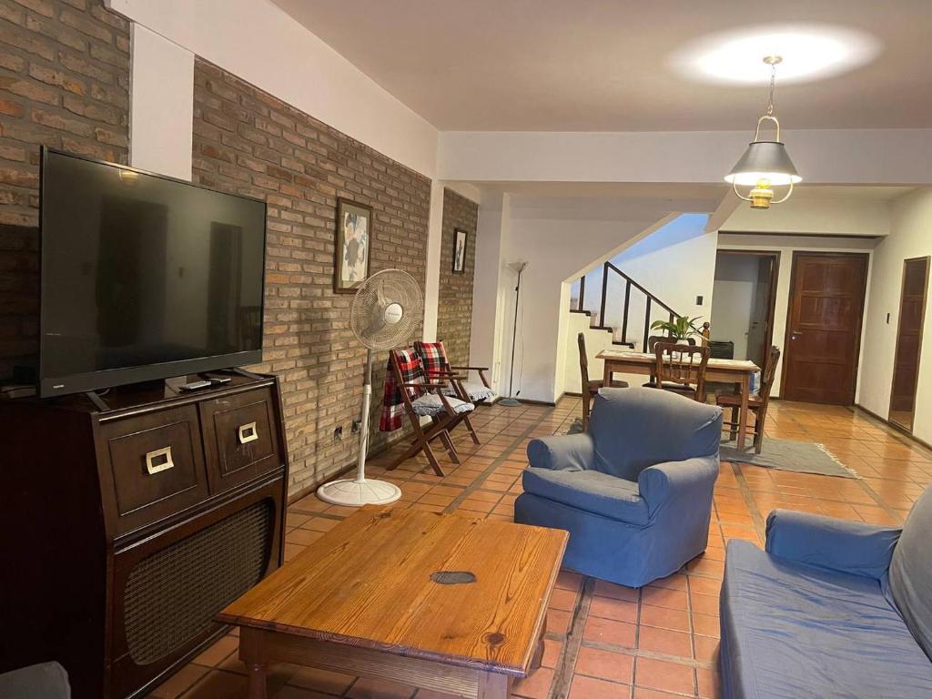 sala de estar con TV de pantalla plana y sillas azules en Casa Céntrica en Gualeguaychú, Pagos en USD en Gualeguaychú