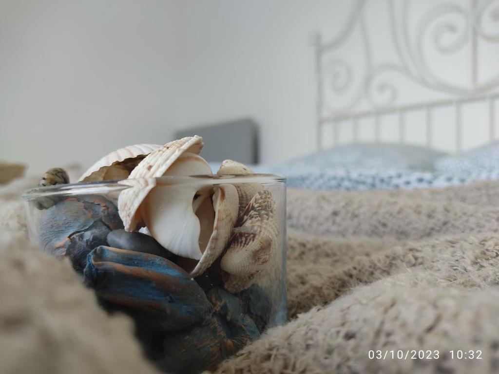a glass jar with a seashell sitting on a bed at Las Hermanas for 2 in Perea