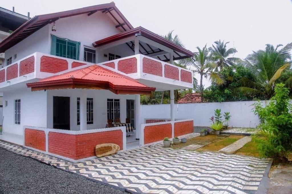 una casa de color rojo y blanco en Mirissa Diamond Beach Villa, en Mirissa